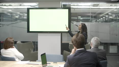 Confident-speaker-talking-and-pointing-at-display